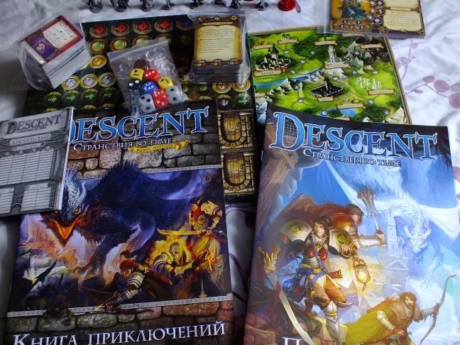 Книги правил Descent, поле кампанії, картки, кубики та пакети з жетонами на столі